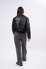 Campera biker de cuero sintético negro con cierre asimétrico, solapas anchas, bolsillos con cierre y cinturón ajustable en la cintura con hebilla metálica.