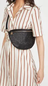 Riñonera negra tejida con correa de cuero ajustable y cadena de eslabones grandes de acrílico.