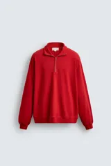 Sudadera de algodón ligero en color rojo, con cuello subido y cierre frontal de cremallera. Presenta mangas largas con puños acanalados y dobladillo inferior en rib.