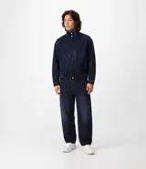 Pantalón de jean azul oscuro con corte Baggy Balloon, piernas amplias con leve ajuste en los puños, recortes anatómicos, cierre con botón y cremallera, pasacintos y bolsillos funcionales.