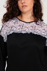 Pijama negro de algodón con detalle de puntilla bicolor en el escote. El pantalón es de tiro alto y corte recto.