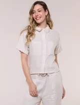 Conjunto de dos piezas confeccionado en lino, de estilo casual safari. Incluye camisa de manga corta con cuello camisero con bordado festoneado, abotonadura frontal y bolsillos en el pecho; y pantalón palazzo de tiro alto con bolsillos y cinturón con hebilla metálica dorada.