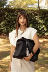 Bolso tipo shopper color rojo, confeccionado en 100% cuero vacuno, con diseño geométrico de paneles y detalle de fleco decorativo colgante.