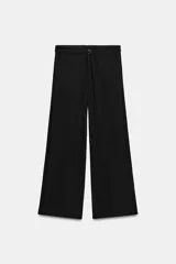 Pantalón de tiro bajo y corte recto, color negro, con bolsillos delanteros y cinturón integrado del mismo tejido con hebilla metálica.