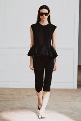 Top negro de manga sisa de Zara Woman Collection, confeccionado en mezcla de algodón, con cuello redondo y bajo acabado en peplum fruncido.