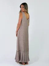 Vestido largo sin mangas, con escote en V, corte holgado y detalles de volados con flecos en el ruedo.