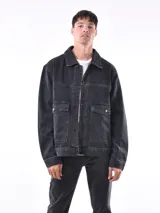 Campera de jean negra con lavado oscuro, corte oversize y cuello camisero. Presenta bolsillos grandes con tapa y botón en el pecho.