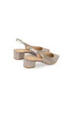 Zapato tipo slingback color peltre metalizado, con punta fina y taco cuadrado bajo. Presenta una tira ajustable con hebilla en el talón.