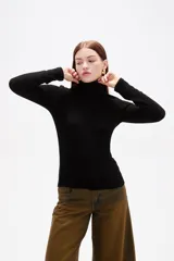 Polera de viscosa color negro, de corte ajustado al cuerpo, con cuello alto y mangas largas.