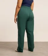 Pantalón recto verde oscuro con cintura elástica y vivos laterales blancos.