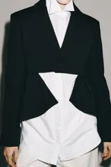 Blazer asimétrica de Zara Woman Collection, confeccionada con mezcla de lana. Presenta cuello solapa, manga larga con botones, cierre frontal con un botón y bajo asimétrico con abertura. Incluye forro interior a tono.