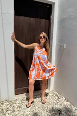 Vestido corto sin mangas con estampado abstracto en tonos naranja y celeste.