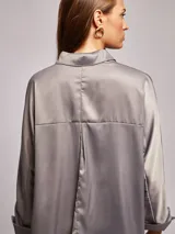 Camisa lila de satén, corte amplio, cuello solapa, manga larga y bolsillo de parche en el pecho.