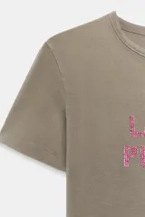 Remera negra de efecto lavado con corte slim fit, cuello redondo y manga corta. Cuenta con un estampado frontal con la frase "100% ICONIC" hecha con aplicaciones de brillos plateados.