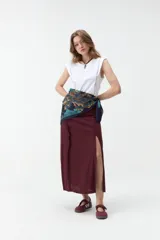 Falda midi bordó con tajo lateral profundo y diseño cruzado.