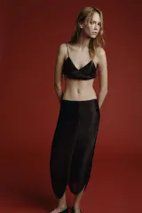 Falda midi de tiro medio, color negro, con aplicación de flecos combinados a tono y bajo asimétrico.