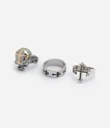 Kit de tres anillos masculinos de metal con acabado envejecido y diseños inspirados en el estilo urbano y alternativo, incluyendo calavera en relieve, cruz aplicada y cruces grabadas.