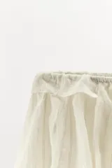 Shorts de tiro bajo con diseño abullonado, confeccionado en tejido ligero con sutiles rayas verticales. Presenta cintura elástica ajustable con cordón y detalle de volantes en la parte superior.