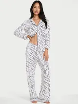 Set de pijama largo de modal ultrasuave, compuesto por una blusa de manga larga con botones al frente, cuello con solapas y ribetes contrastantes, y un pantalón largo con cintura elástica y cordón ajustable. Diseño con estampado de lunares.