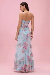 Vestido largo Patbo de color celeste con estampado floral, escote palabra de honor (strapless), diseño con corset translúcido y falda larga con múltiples volados.