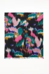 Pashmina de tejido suave con diseño de estampado abstracto multicolor en tonos vibrantes y bordes desflecados.