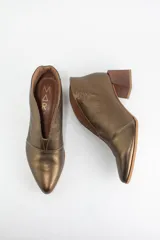 Botines de cuero color beige con diseño de tajo frontal, punta fina y taco cuadrado de madera.