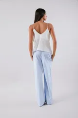 Pantalón celeste a rayas verticales blancas, de corte palazzo y cintura alta con elástico.