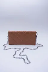 Cartera de cuero color marrón claro, con diseño capitoneado y cadena metálica plateada removible. Tiene ranuras interiores para tarjetas y documentos, y forro textil rojo.