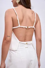 Blusa blanca sin mangas con tirantes finos y escote cuadrado.