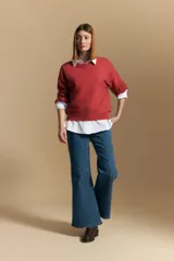 Sweater color crema con mangas abullonadas y puños elastizados. Presenta una textura tejida en relieve con patrón de ladrillos en el cuerpo y rayas horizontales en las mangas.