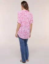 Camisa de lino sintético con estampado floral en tonos azules y beige sobre fondo blanco, de corte holgado, mangas tres cuartos y cuello camisero.