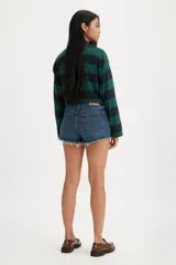 Short de denim de tiro bajo para mujer, confeccionado en algodón con baja elasticidad. Presenta un lavado azul medio con efecto desgastado, diseño de cinco bolsillos y dobladillo deshilachado con flecos.