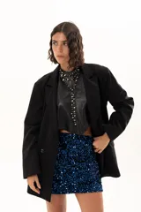Blazer negro de corte oversize con solapas clásicas, cierre frontal de doble botonadura y bolsillos laterales con solapa.