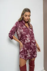 Vestido corto color beige con estampado de paisajes en marrón, cuello mao y mangas largas con puños abotonados.