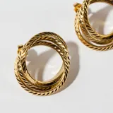 Aros dorados con diseño de tres aros entrelazados con textura trenzada.