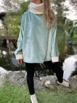 Polerón celeste de peluche con cuello alto y puños blancos.