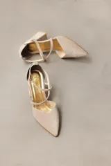 Zapato de taco alto azul oscuro, confeccionado en gamuza, con diseño de punta fina, escote en V y tiras cruzadas en diagonal con hebilla ajustable en el tobillo.