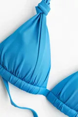 Top de bikini push-up con copas de triángulo color celeste, tiras para anudar al cuello y en la espalda.