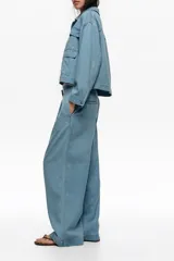 Pantalón vaquero de corte wide leg, confeccionado en algodón de tiro bajo, con bolsillos laterales y traseros, en tono celeste claro.