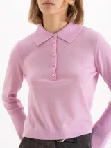 Sweater de punto color rosa, con cuello polo, cierre frontal con botones y mangas largas con puños acampanados.