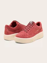 Championes Sorel modelo Ona Ave Low de gamuza rosada, con suela plataforma estriada color beige y el nombre de la marca impreso en dorado en el lateral.