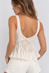Top de encaje blanco con tirantes finos, escote en V y diseño con volados en la parte inferior.