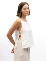 Musculosa de lino con cuello redondo, diseño holgado y laterales abiertos unidos por tres tiras horizontales.