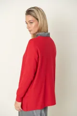 Buzo verde oliva de punto fino con detalle de líneas diagonales en el mismo material y cuello camisero blanco.