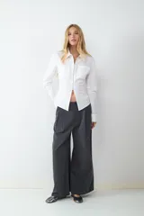 Pantalón de vestir de tiro alto con pliegues frontales, corte amplio y pernera recta. Cuenta con bolsillos laterales y cierre frontal con cremallera y botón.