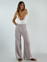 Pantalón de lino color marrón con paneles laterales en color crema y corte acampanado.