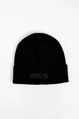 Gorro de punto negro con vuelta y bordado con la palabra "BROOKLYN" en el frente.