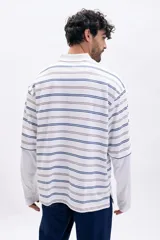 Sudadera tipo polo a rayas horizontales en blanco, azul y marrón claro, con cuello blanco y doble manga larga blanca.