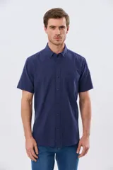 Camisa de manga corta confeccionada en mezcla de lino y algodón, color beige, con cuello camisero abotonado, bolsillo frontal en el pecho y cierre de botones.