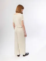 Pantalón ancho de tejido de punto acanalado color gris claro, con tiro alto y caída fluida.